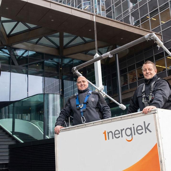 Glazenwassers in een gondel voor een bedrijfspand