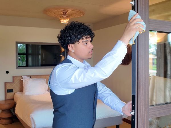 Schoonmaakmedewerker aan het werk in een hotelkamer
