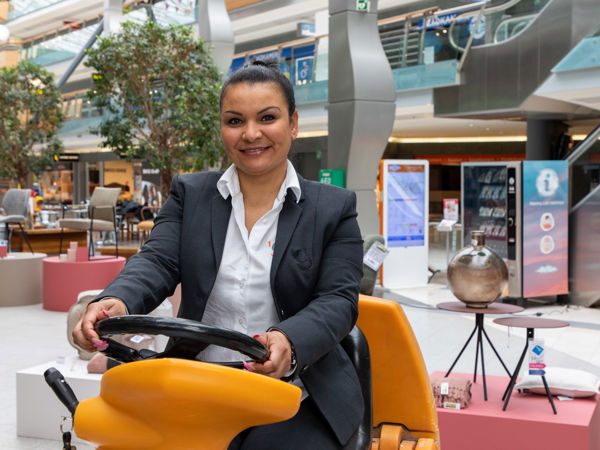 Schoonmaakmedewerker die de vloer aan het schoonmaken is op een schrobmachine