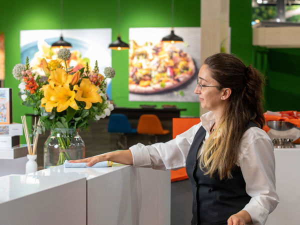 Schoonmaakmedewerker aan het afstoffen