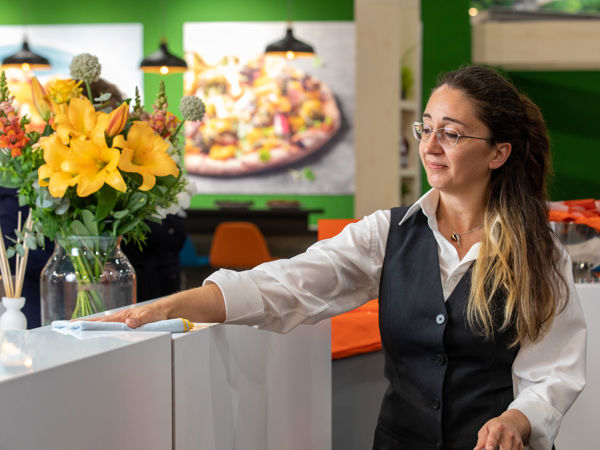 Schoonmaakmedewerker aan het afstoffen