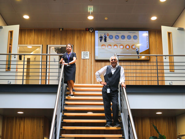 Schoonmaakmedewerkers verwelkomen je in een bedrijfspand