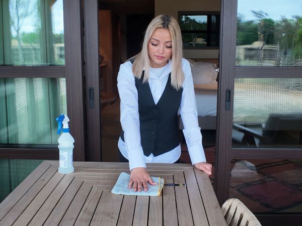 Schoonmaakmedewerker die een tafel schoonmaakt